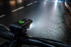 Gros plan sur un feu avant de vélo bien réglé qui éclaire la route pour une meilleure visibilité